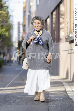 Smiling senior woman walking in the city Smiling senior woman walking in the city 137223505