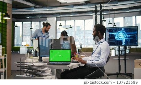 Startup office programmer using green screen laptop, developing artificial intelligence models for business analytics. IT expert using mockup notebook, running simulations for AI forecasting, camera A 137223589