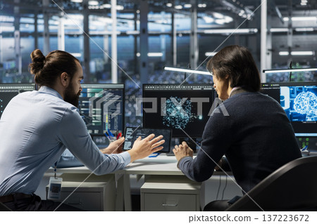 Technicians in data center installing upgraded server racks systems helped by AI technology. Server hub workers upgrading enterprise networks hardware using artificial intelligence 137223672