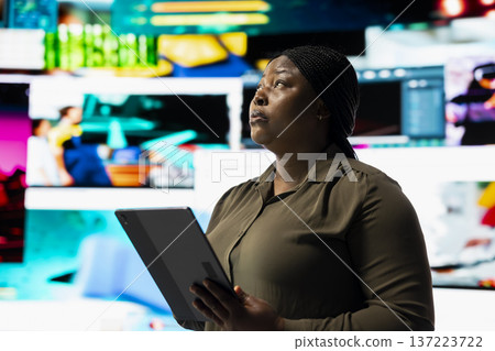 Woman using device to look at social media feed mapping global entertainment content. Person surrounded by floating icons uses and interactive digital interface on tablet to do social media engagement Woman using device to look at social media feed mapping global entertainment content. Person surrounded by floating icons uses and interactive digital interface on tablet to do social media engagement 137223722