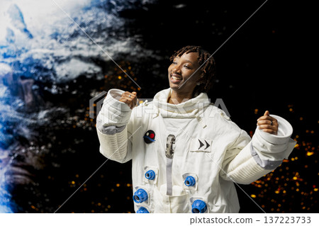 Joyful astronaut dancing, celebrating reaching planet during scientific mission. Happy African american cosmonaut in high tech spacesuit excited after successfully landing on outer space planet 137223733