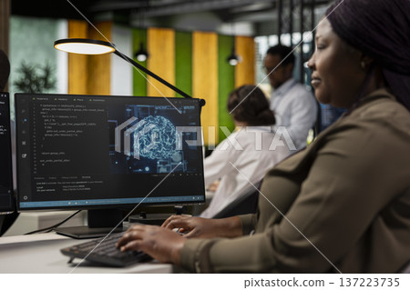 System administrator in AI tech company workplace using PC to conduct code reviews. IT specialist using computer program at office desk to design and implement machine learning algorithms 137223735