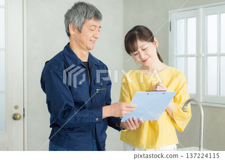 A man in work clothes explaining about plumbing 137224115