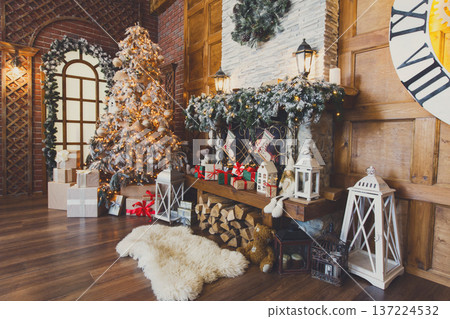 Beautiful christmas interior. Warm room with fireplace, decorated christmas tree, lots of presents and huge clock on wooden wall. Cozy home for winter holidays, copy space, side view Beautiful christmas interior. Warm room with fireplace, decorated christmas tree, lots of presents and huge clock on wooden wall. Cozy home for winter holidays, copy space, side view 137224532