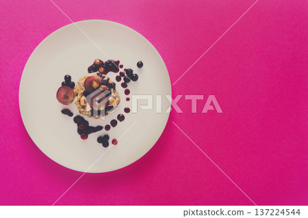 Healthy breakfast, dieting and detox concept - wholegrain fresh oatmeal porridge on plate with fruits, berries and nuts on pink background, top view, copy space Healthy breakfast, dieting and detox concept - wholegrain fresh oatmeal porridge on plate with fruits, berries and nuts on pink background, top view, copy space 137224544
