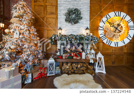 Beautiful holdiay living room with lots of presents under decorated christmas tree, fireplace and huge clock on wooden wall. Winter holiday design and decorations background 137224548