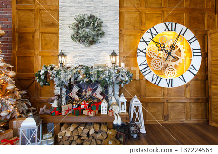 Beautiful holdiay living room. Fireplace decorated with fir tree wreath and garland. Winter holiday design and decorations background Beautiful holdiay living room. Fireplace decorated with fir tree wreath and garland. Winter holiday design and decorations background 137224563