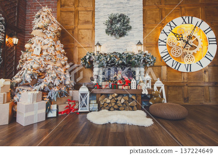 Beautiful christmas interior. Warm room with fireplace, decorated christmas tree, lots of presents and huge clock on wooden wall. Cozy home for winter holidays, copy space Beautiful christmas interior. Warm room with fireplace, decorated christmas tree, lots of presents and huge clock on wooden wall. Cozy home for winter holidays, copy space 137224649