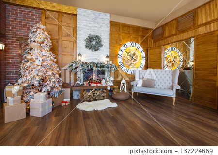 Beautiful christmas interior. Warm room with fireplace, decorated christmas tree, lots of presents and huge clock on wooden wall. Cozy home for winter holidays, copy space 137224669