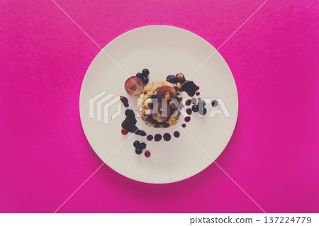Healthy breakfast, dieting and detox concept - wholegrain fresh oatmeal porridge on plate with fruits, berries and nuts on pink background, top view. Healthy breakfast, dieting and detox concept - wholegrain fresh oatmeal porridge on plate with fruits, berries and nuts on pink background, top view. 137224779