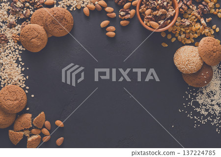 Healthy organic natural oat cookies and nuts on dark background, copy space. Flat lay, top view, mockup. Healthy organic natural oat cookies and nuts on dark background, copy space. Flat lay, top view, mockup. 137224785