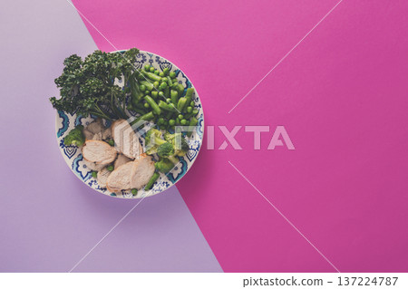 Healthy food, diet nutrition. Green steamed vegetables and slices of chicken on bright geometric background, top view, copy space Healthy food, diet nutrition. Green steamed vegetables and slices of chicken on bright geometric background, top view, copy space 137224787
