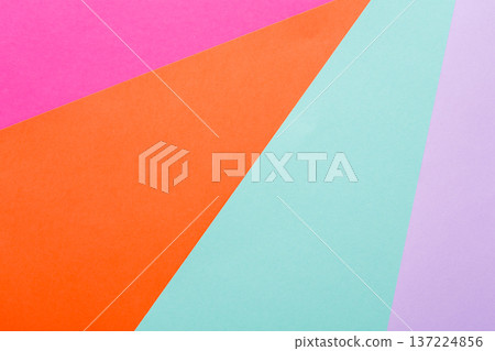 Brightly colored paper in shades of pink, orange, teal, and purple forms an abstract arrangement. The geometric shapes create a lively backdrop that adds visual interest to any project. 137224856
