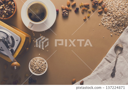 Flat lay of breakfast meal - cup of coffee, oat and nuts on beige table background. Still life, copy space, Mockup, template. 137224871