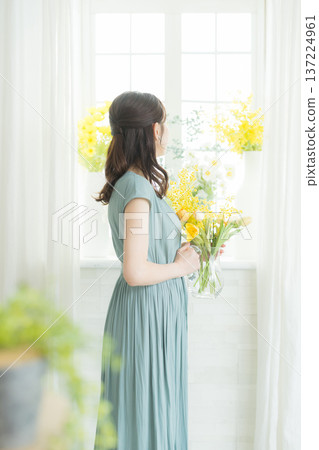 女子在窗台上插花。 137224961