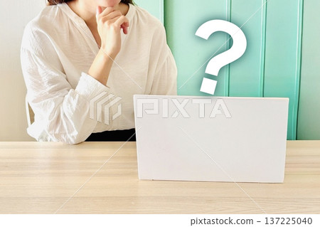 A woman thinking in front of a laptop A woman thinking in front of a laptop 137225040