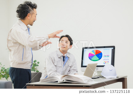 工程師們在辦公室一邊開會一邊查看文件。 137225118