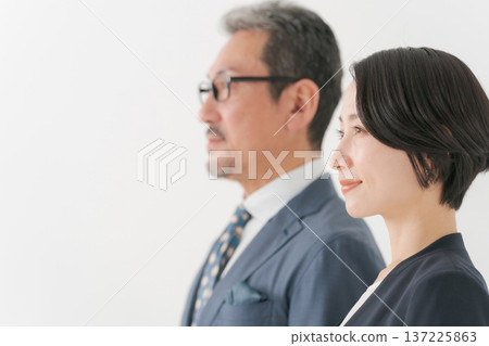 Male and female business people standing side by side Male and female business people standing side by side 137225863