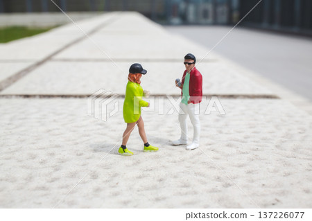 Miniature figures engage in conversation on raised outdoor platform 137226077