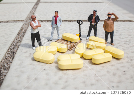 Miniature workers gather around scattered yellow cargo pieces Miniature workers gather around scattered yellow cargo pieces 137226080