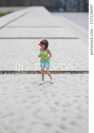 Miniature figurine standing alone on wide textured walkway Miniature figurine standing alone on wide textured walkway 137226097