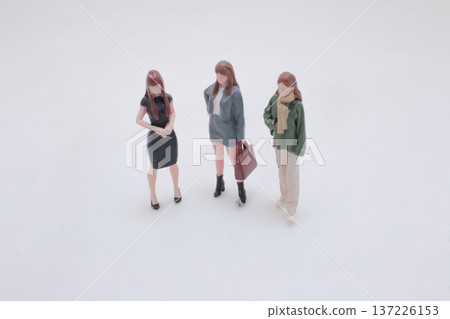 Three Miniature Figures Stand Together in Varied Outfits Three Miniature Figures Stand Together in Varied Outfits 137226153