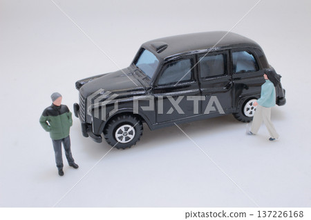 Miniature Figures Positioned Next To Classic Black Vehicle Miniature Figures Positioned Next To Classic Black Vehicle 137226168