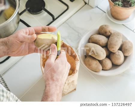 Man's hands peel a potato Man's hands peel a potato 137226497