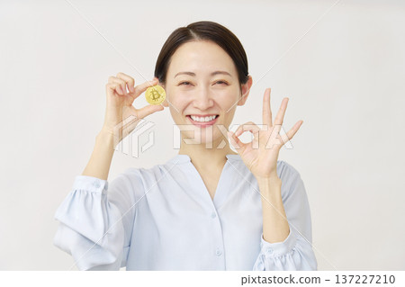 Woman holding bitcoin on white background 137227210