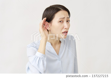 Hearing-impaired woman in her 40s on white background Hearing-impaired woman in her 40s on white background 137227215