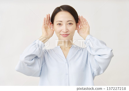 Woman in her 40s listening carefully, white background 137227218