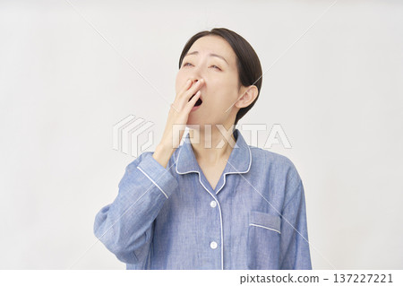 Yawning woman in pajamas on white background 137227221