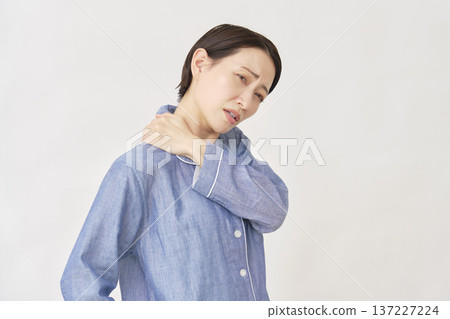 Woman in pajamas with stiff shoulders, white background Woman in pajamas with stiff shoulders, white background 137227224