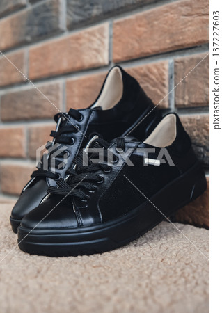 Elegant black leather womens shoes blank product for branding displayed. New casual female sneakers no-brand footwear e-commerce. No logo product 137227603