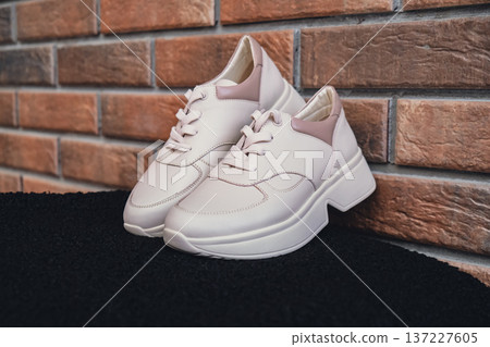 Fresh beige leather sneakers without brand marks displayed. For design templates online shops and sustainability-themed marketing. Clean blank sneakers 137227605