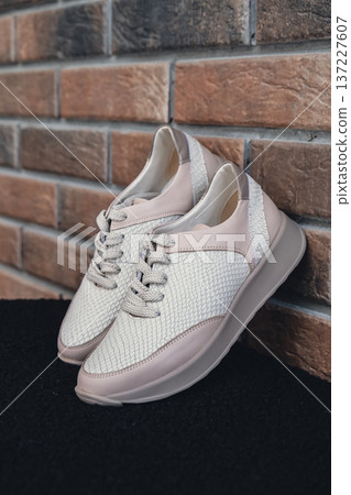 Fresh beige leather sneakers without brand marks displayed. For design templates online shops and sustainability-themed marketing. Clean blank sneakers 137227607