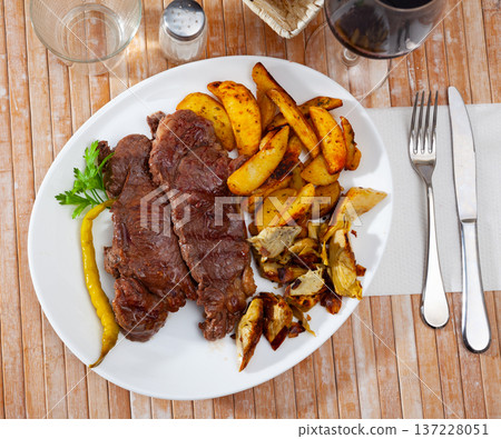Beef steak with potatoes and artichokes Beef steak with potatoes and artichokes 137228051
