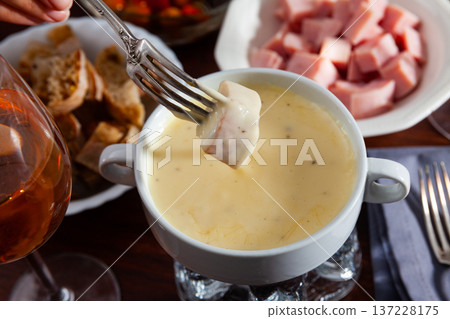 Dinner with cheese fondue, sausages and bread 137228175