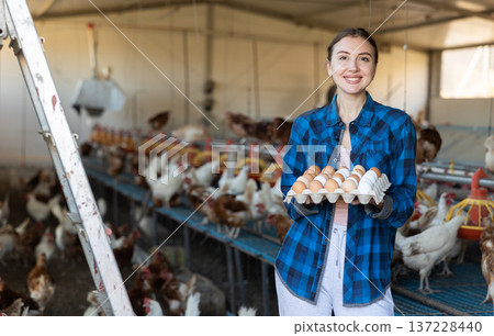 Portrait of woman farmer holding fresh eggs in hands in henhouse Portrait of woman farmer holding fresh eggs in hands in henhouse 137228440