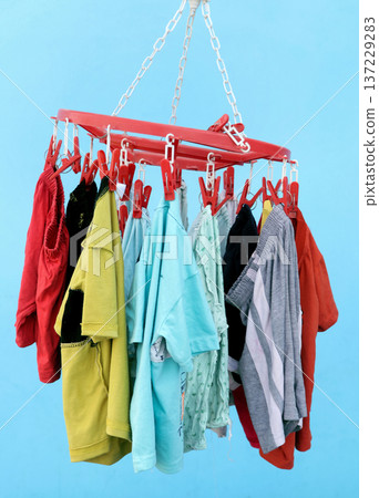Colorful baby Clothes Hanging on Plastic Clip Hanger 137229283