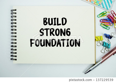 Build Strong Foundation text message written on notepad with stationery flat lay on white background Build Strong Foundation text message written on notepad with stationery flat lay on white background 137229539
