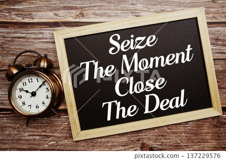 Seize The Moment Close The Deal text on Blackboard and alarm clock on wooden background Seize The Moment Close The Deal text on Blackboard and alarm clock on wooden background 137229576