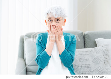 坐在沙發上的老婦人一臉驚訝 137230420