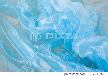 Close-up of blue crumpled plastic bags symbolizing ocean pollution and environmental damage. Abstract environmental background, text space Close-up of blue crumpled plastic bags symbolizing ocean pollution and environmental damage. Abstract environmental background, text space 137231966