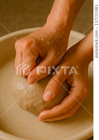 Close-up of hands kneading clay in pottery 137231981