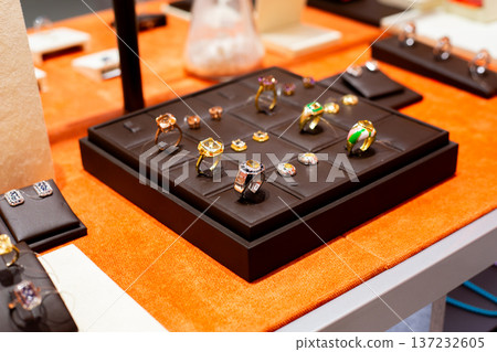 Display of matching rings and earrings. Jewelry set for cohesive look. Create harmonious style and coordinate jewelry with ring and earring set. Stand on jewelry shelf Display of matching rings and earrings. Jewelry set for cohesive look. Create harmonious style and coordinate jewelry with ring and earring set. Stand on jewelry shelf 137232605