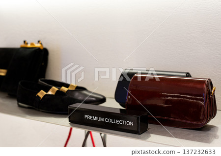 Shelf in clothing and shoe store with premium collection. Expensive items on shelf of elite clothing store. Shopping in exclusive boutiques. Life of luxury with constant purchases Shelf in clothing and shoe store with premium collection. Expensive items on shelf of elite clothing store. Shopping in exclusive boutiques. Life of luxury with constant purchases 137232633