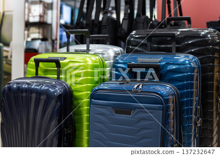 Suitcases of various sizes at travel store. Finding suitcase by size and style is challenging. Wide selection of wheeled bags with retractable handles. Unique design and color for airplane bag Suitcases of various sizes at travel store. Finding suitcase by size and style is challenging. Wide selection of wheeled bags with retractable handles. Unique design and color for airplane bag 137232647