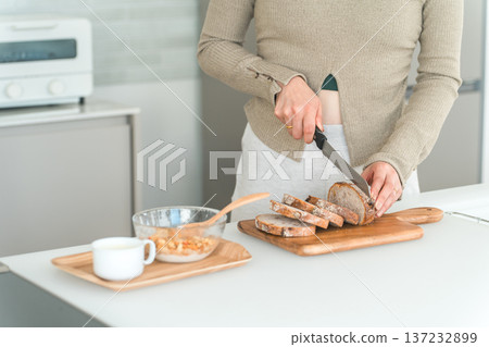 女人的手在廚房切麵包做早餐。 女人的手在廚房切麵包做早餐。 137232899