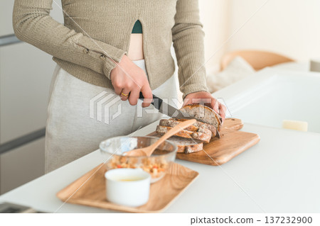 女人的手在廚房切麵包做早餐。 女人的手在廚房切麵包做早餐。 137232900
